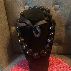 Long chunky black plastic necklace with ribbon tie